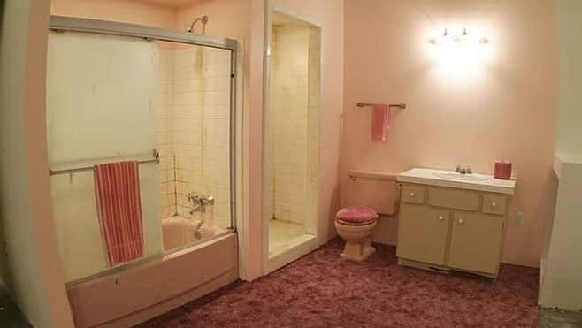 Inside white and light pink Bathroom with shower door and sink.